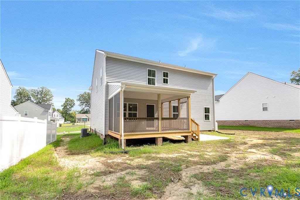 Rear exterior featuring a screened porch, a wood deck, light-colored siding, and a concrete patio