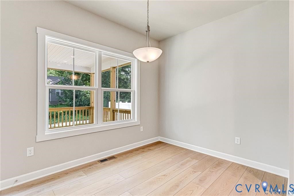 Hardwood flooring, painted walls, contemporary overhead light fixture, and a large window with white trim