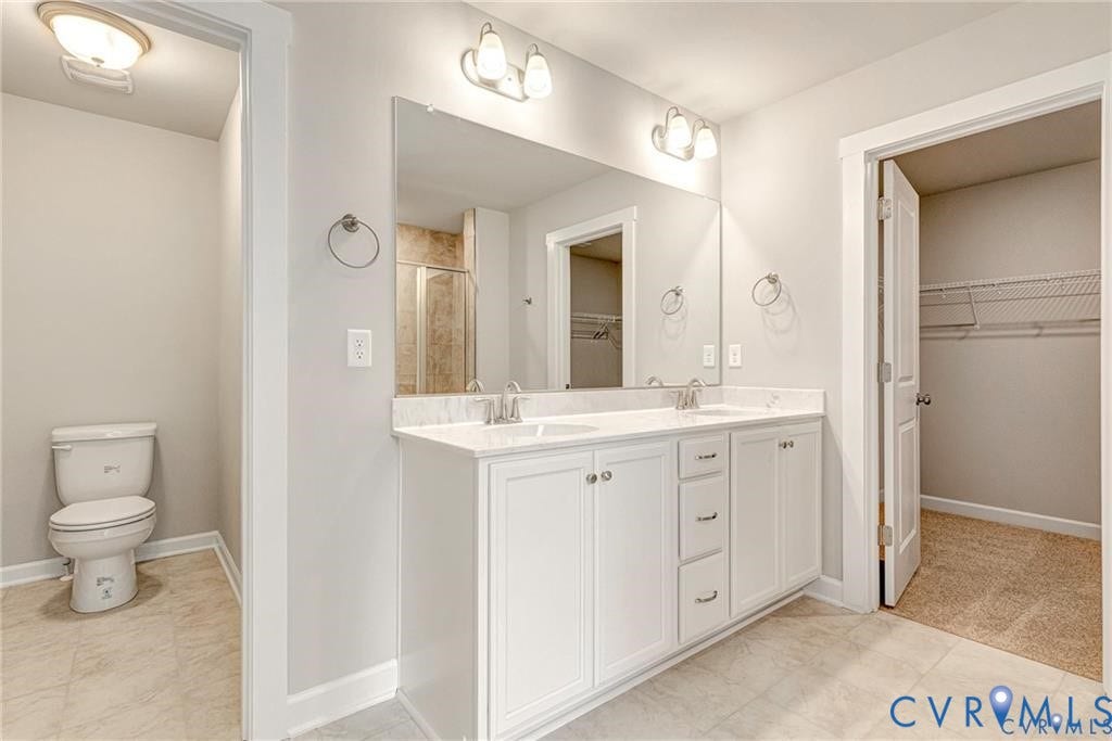 Double vanity with white cabinetry, dual undermount sinks, and a light-toned countertop