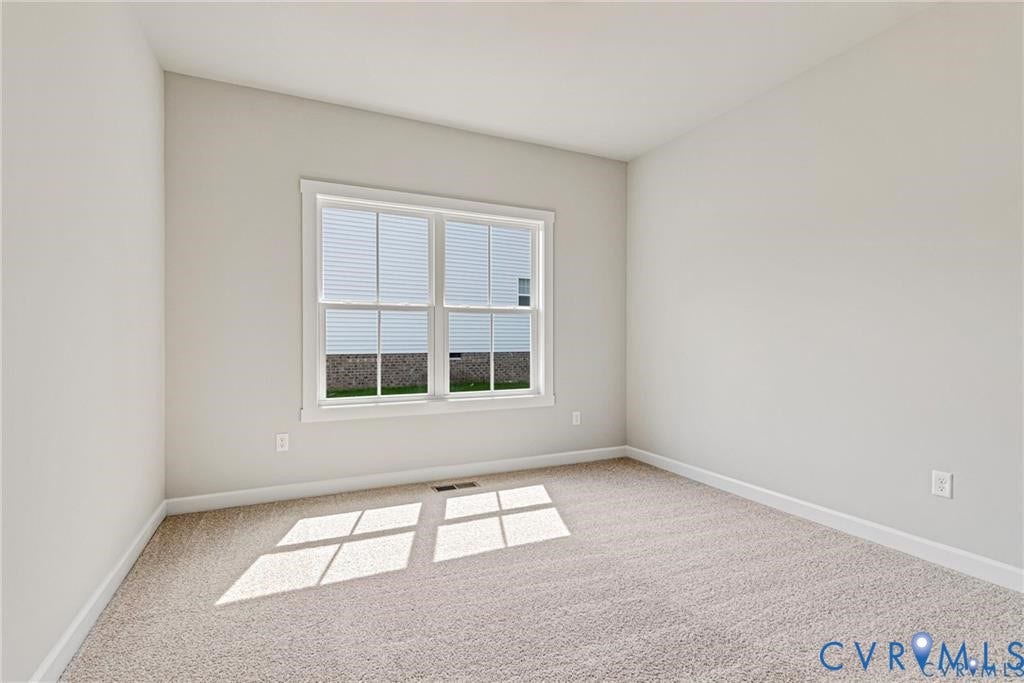 Neutral wall color, carpeted flooring, and a double-hung window with blinds