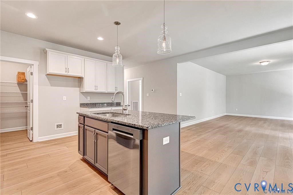 Kitchen island with granite countertop, integrated stainless steel sink, and stainless steel dishwasher