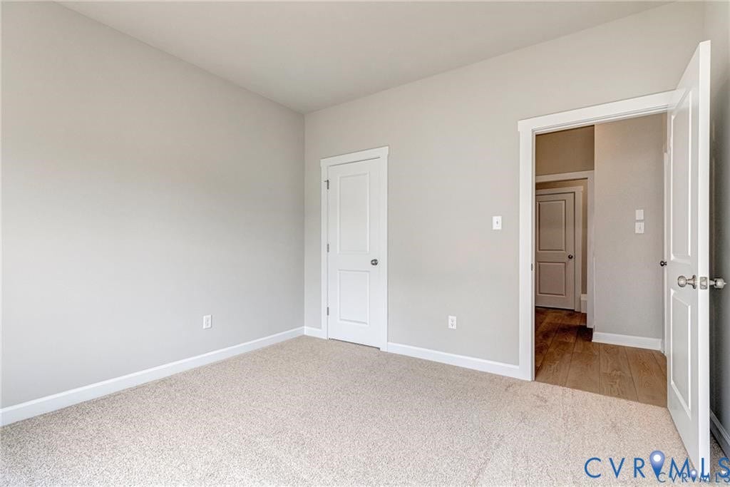 Neutral wall color, wall-to-wall carpeting, white interior doors, and white trim