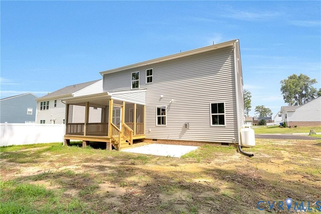 Two-story exterior with light-colored siding, a screened-in porch with wood railings and stairs, and a white fence enclosing a portion of the yard