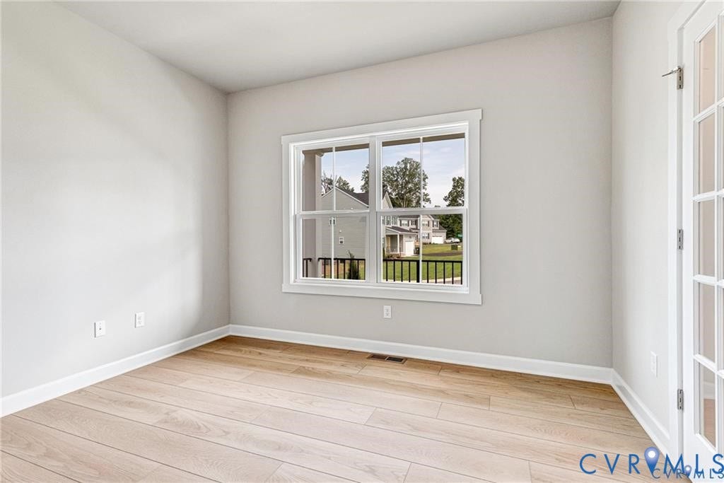 Wood-finish flooring, white trim, dual-pane window, and French doors
