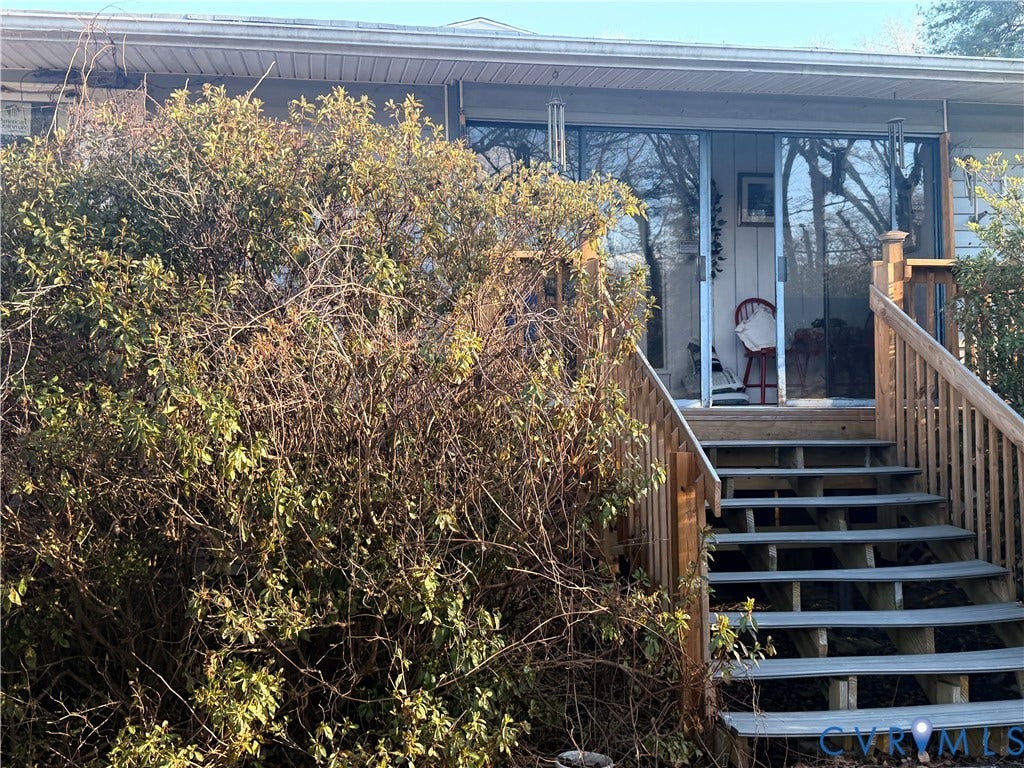 106 Hickory Drive, Goochland, VA 23103 Exterior wood staircase with matching handrails leading to sliding glass doors and a residential siding facade