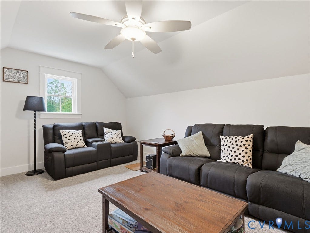 Vaulted ceilings featuring a central white ceiling fan with integrated lighting and a single pane window with trim