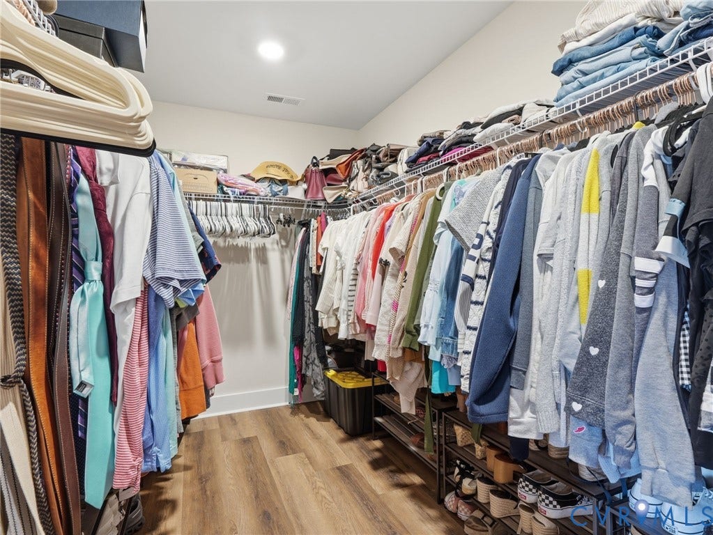 Walk-in closet featuring wood-finish flooring and tiered wire shelving
