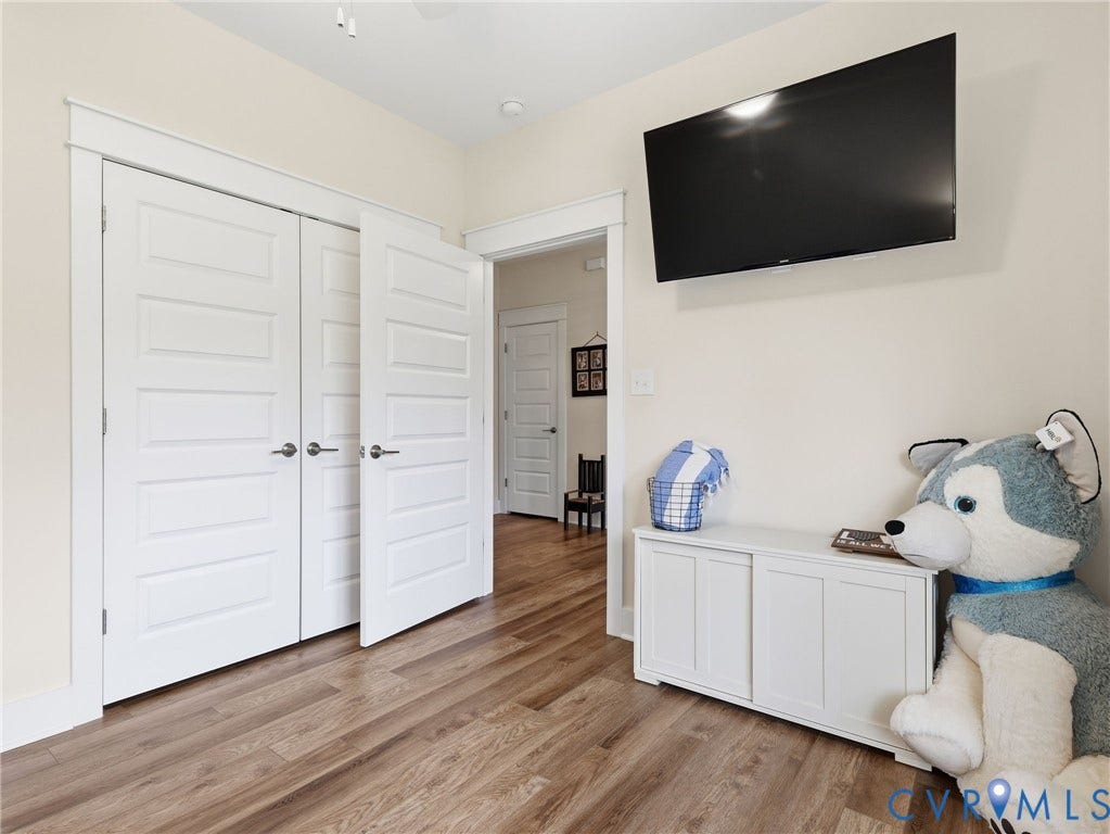 Wood-finish flooring, white five-panel interior doors, and crisp white door casings throughout