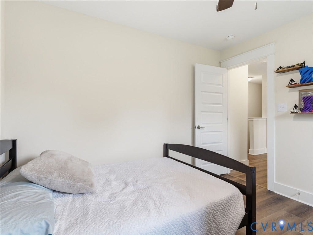 Neutral wall finishes, wood-finish flooring, and a five-panel interior door with satin nickel hardware