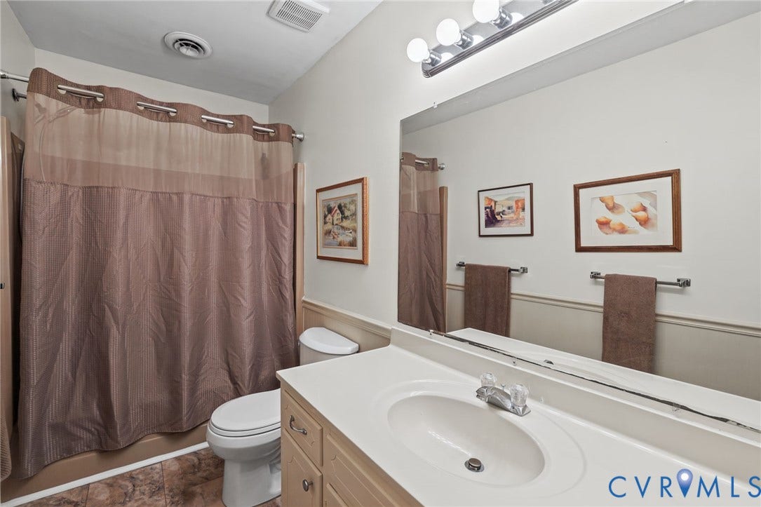 4815 Woodbriar Court, Midlothian, VA 23112 Bathroom featuring a vanity with integrated sink and countertop, a full-width wall-mounted mirror, a four-light fixture, and a shower-tub combination