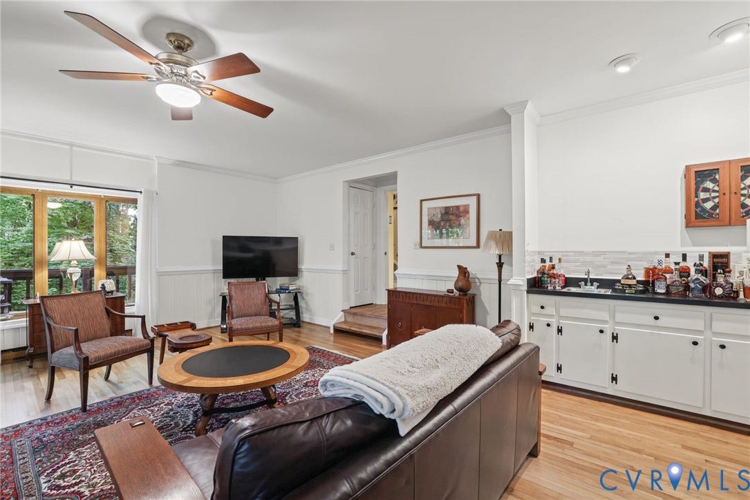 4815 Woodbriar Court, Midlothian, VA 23112 Living area featuring wood-finish flooring, a wet bar with white cabinetry and dark countertops, beadboard wainscoting, and a ceiling fan with integrated lighting