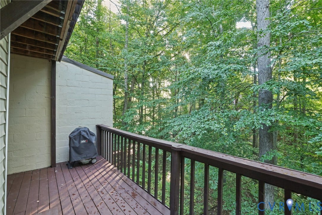 4815 Woodbriar Court, Midlothian, VA 23112 Elevated deck featuring wood-finish decking and a wooden balustrade, complemented by surrounding mature trees