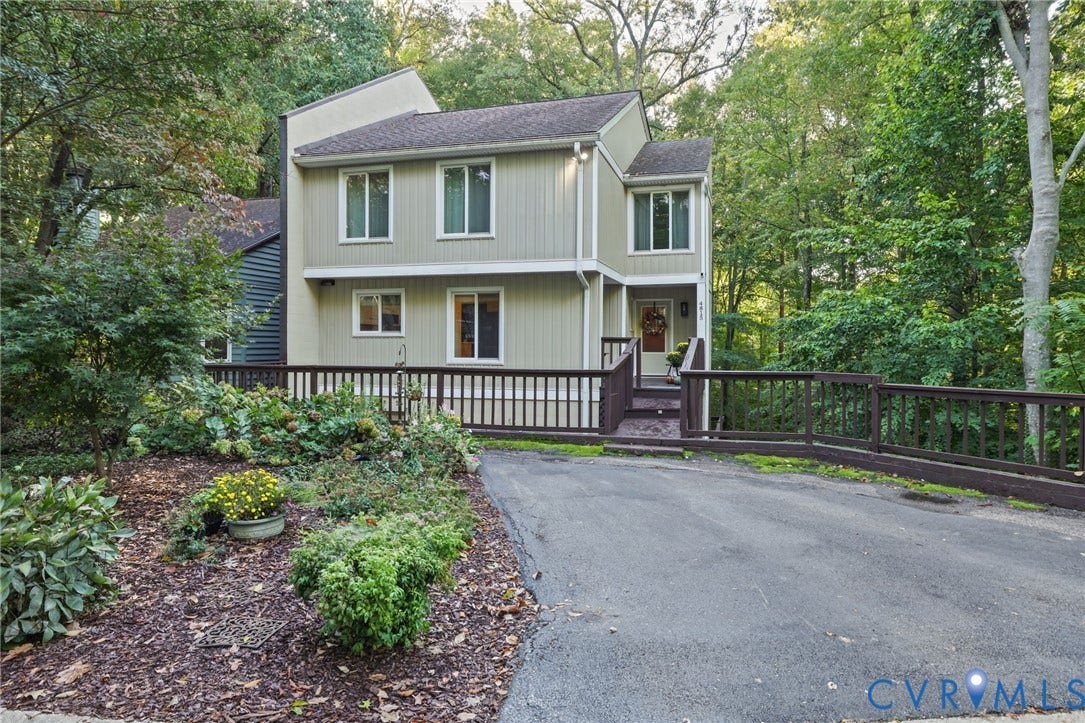 4815 Woodbriar Court, Midlothian, VA 23112 Multi-level exterior featuring vertical siding, a paved driveway, and an attached wood-railing deck nestled among mature trees