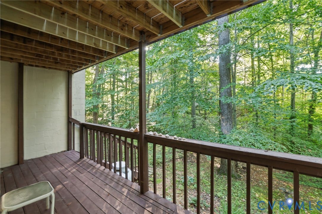 4815 Woodbriar Court, Midlothian, VA 23112 Covered lower-level patio featuring stained wood decking, wood-post support structure, and a perimeter railing overlooking a wooded area