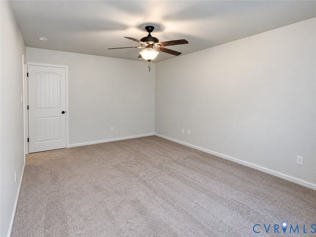 Neutral wall paint, light-toned carpet flooring, ceiling fan with integrated lighting, recessed ceiling lighting, and a paneled interior door