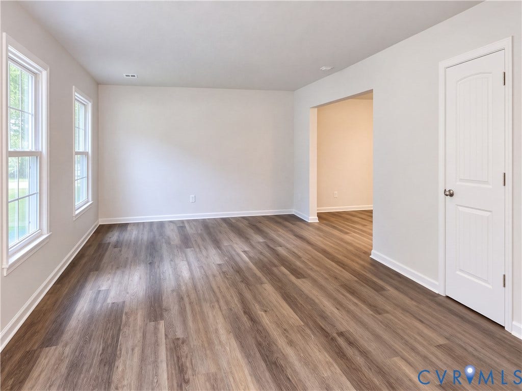Wood-finish flooring, white trim throughout, and multiple windows