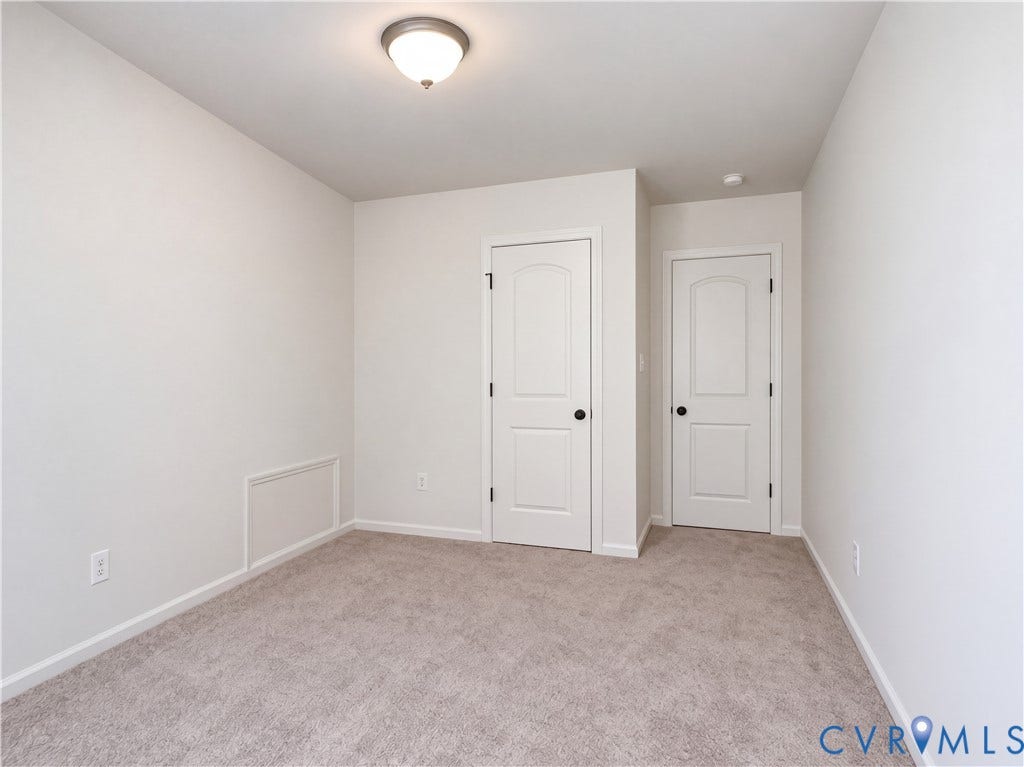 Neutral-toned wall-to-wall carpeting and walls