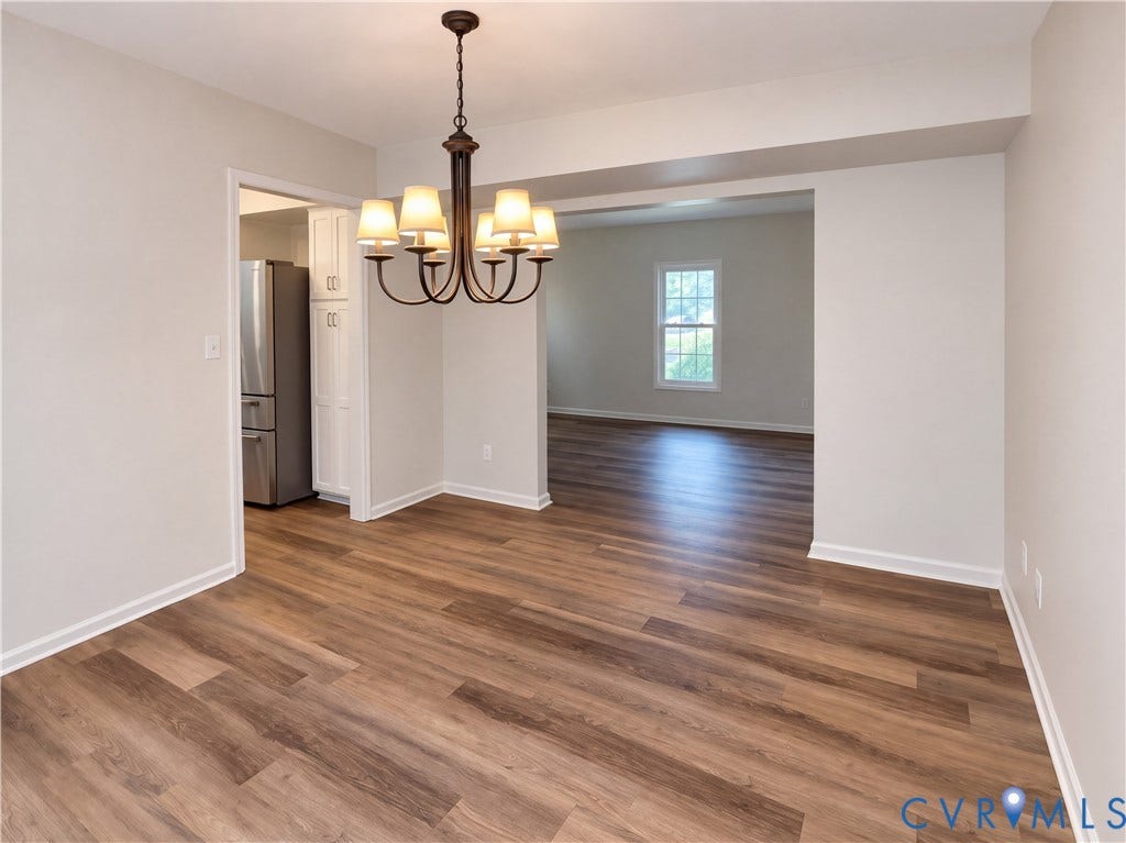 Wood-finish flooring, recessed lighting, and a multi-arm chandelier illuminate the space