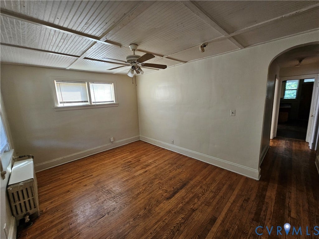 613 E Brookland Park Boulevard, #2, Richmond, VA 23222 Spacious interior room featuring hardwood flooring, ceiling fan with brushed metal finish, and abundant natural light from dual windows