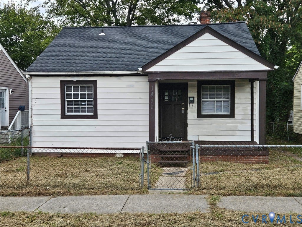 1410 E 18th Street, Richmond, VA 23224 Siding exterior with dark trim accents, covered front entry, dark front door, and a gabled roof