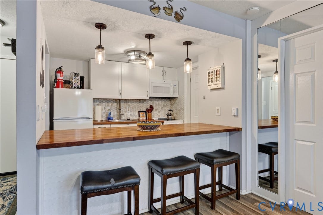 1836 FAIRWAY Drive, #218, Aspen East, Basye, VA 22810 Wood-finish flooring, white cabinetry, integrated microwave, pendant lighting, and a built-in breakfast bar with a wood-finish countertop