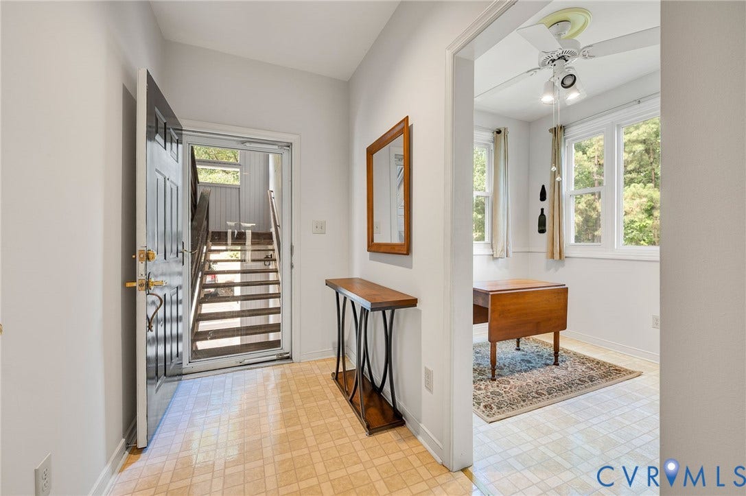 Entryway featuring neutral wall tones, ceramic tile flooring, and a multi-pane glass storm door