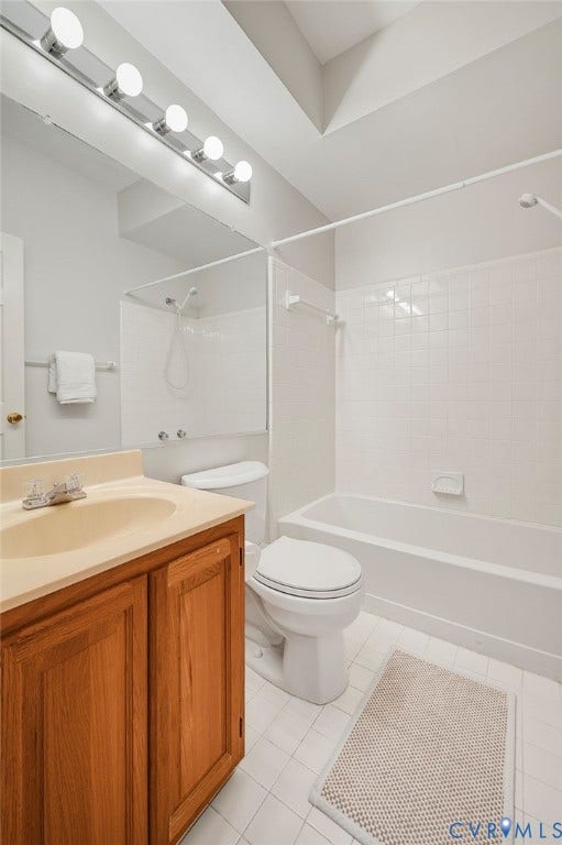 Full bathroom featuring a wood-finish vanity, large wall-mounted mirror, five-light fixture, and a tiled tub-shower combination