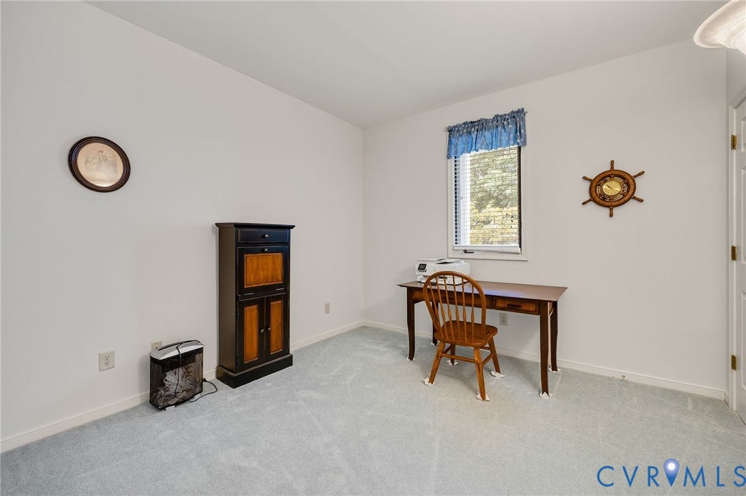 Room featuring neutral wall-to-wall carpeting and a single-hung window with a valance
