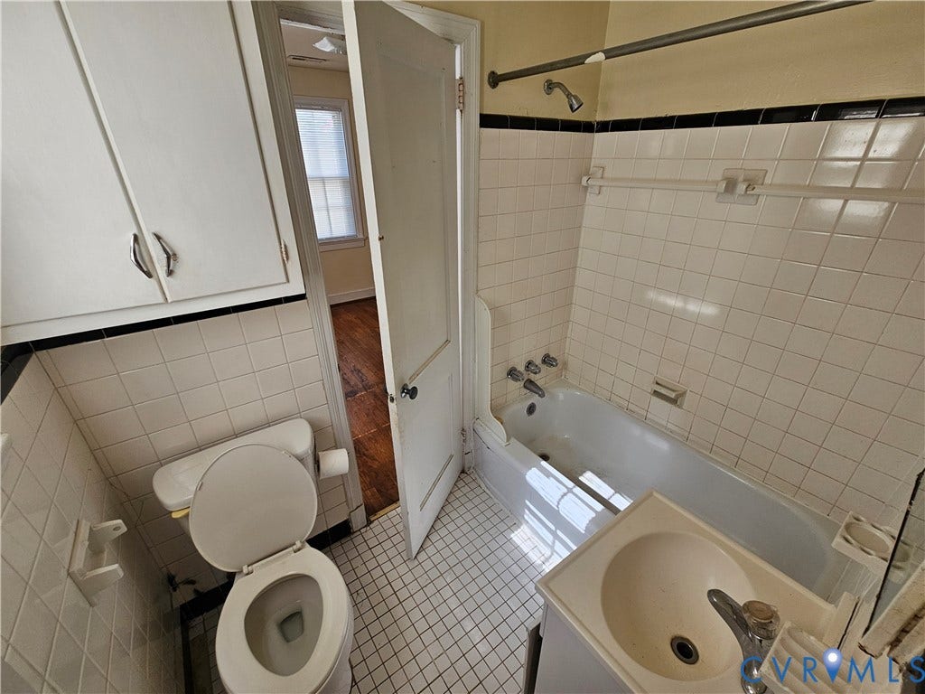 3814 Thimble Lane, Henrico, VA 23222 Bathroom featuring a built-in bathtub with shower, white square tile surround, pedestal sink with vanity, and overhead storage cabinets
