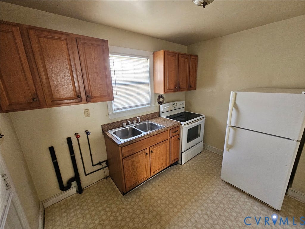 3814 Thimble Lane, Henrico, VA 23222 Kitchen featuring wood-finish cabinetry, a double basin stainless steel sink, and patterned flooring