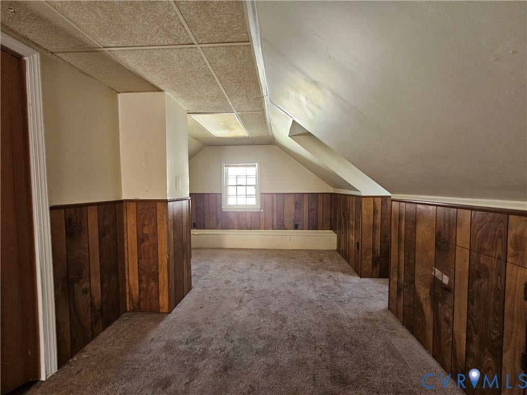 3814 Thimble Lane, Henrico, VA 23222 Sloped ceiling room featuring wood-finish paneling, a single window, and neutral carpeting