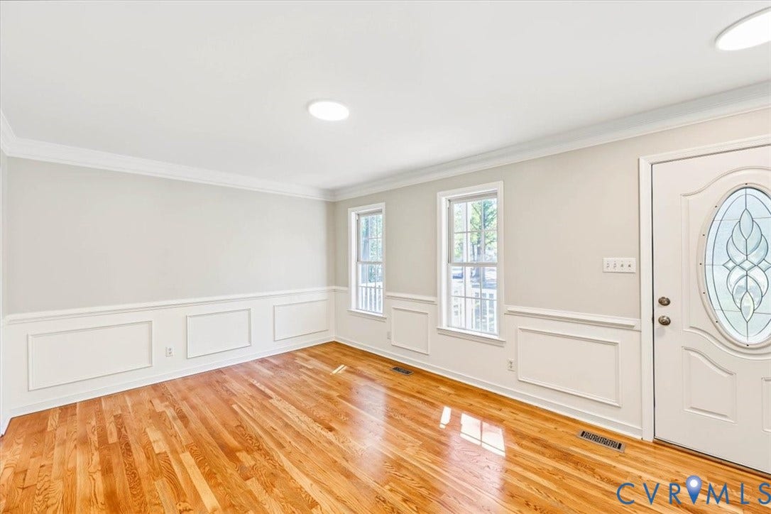 3216 Sherwood Bluff Terrace, Sherwood Bluff, Powhatan, VA 23139 Interior space featuring hardwood flooring, wainscoting, crown molding, double-pane windows, and an entry door with an oval glass insert
