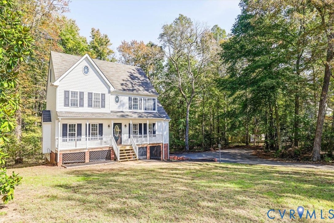 3216 Sherwood Bluff Terrace, Sherwood Bluff, Powhatan, VA 23139 Two-story residence featuring horizontal siding, a covered front porch with a wood-staircase entry, decorative latticework under-porch detailing, and shuttered windows