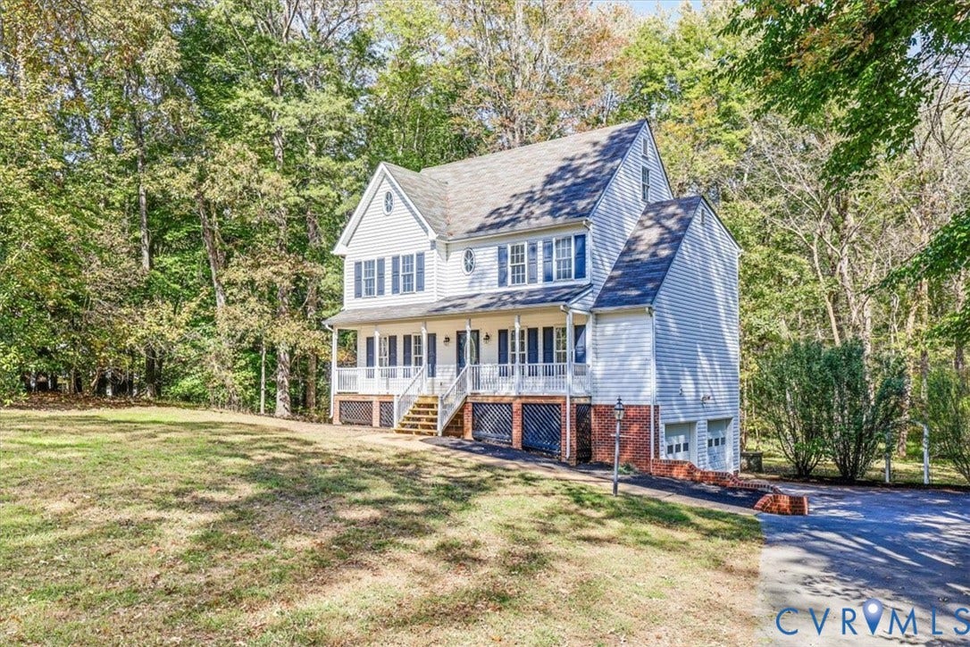 3216 Sherwood Bluff Terrace, Sherwood Bluff, Powhatan, VA 23139 Two-story traditional exterior featuring light-colored horizontal siding, dark shutters, a covered front porch with railings, and a two-car garage