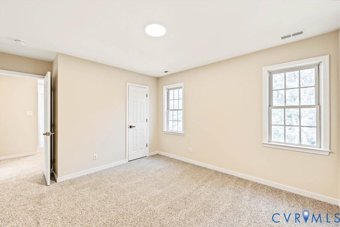 3216 Sherwood Bluff Terrace, Sherwood Bluff, Powhatan, VA 23139 Neutral-toned interior featuring wall-to-wall carpeting, two multi-pane windows, a six-panel door, and a flush-mount ceiling light