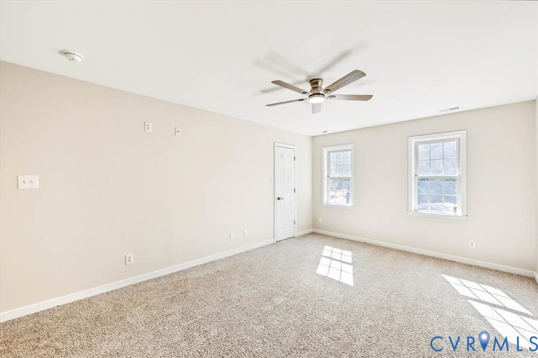 3216 Sherwood Bluff Terrace, Sherwood Bluff, Powhatan, VA 23139 Neutral interior space featuring wall-to-wall carpeting, a multi-blade ceiling fan with integrated lighting, and two double-pane windows with grid mullions