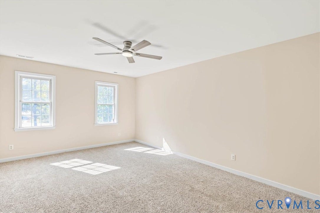 3216 Sherwood Bluff Terrace, Sherwood Bluff, Powhatan, VA 23139 Neutral interior space featuring carpeted flooring, two double-hung windows, and a ceiling fan with integrated lighting