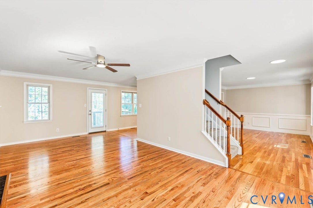 3216 Sherwood Bluff Terrace, Sherwood Bluff, Powhatan, VA 23139 Hardwood flooring, crown molding, ceiling fan with light fixture, staircase with wooden handrail and balusters, and chair rail wainscoting
