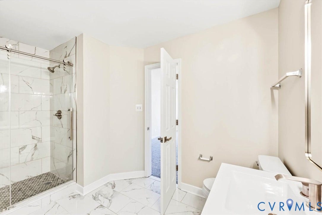 3216 Sherwood Bluff Terrace, Sherwood Bluff, Powhatan, VA 23139 Bathroom featuring a walk-in shower with sliding glass doors and stone-patterned tile, white vanity with integrated sink, and polished metal fixtures