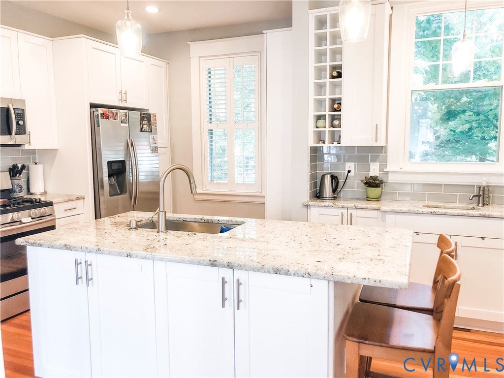 4216 Stonewall Avenue, Richmond, VA 23225 Kitchen featuring white cabinetry, light-colored countertops, stainless steel appliances, a center island with an integrated sink, and a tiled backsplash