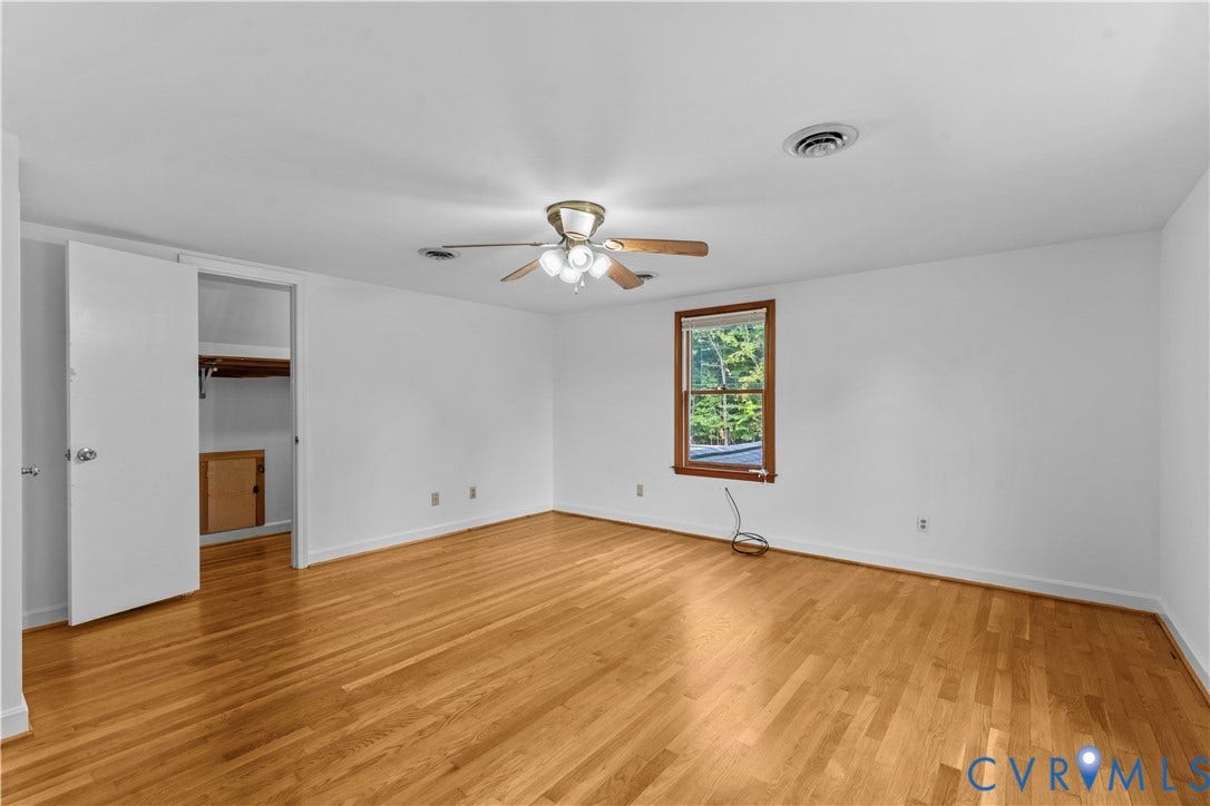 11612 Yorkdale Drive, Rivers Edge, North Prince George, VA 23860 Expansive room featuring wood-finish flooring, a ceiling fan with integrated lighting, a single window with wood trim, and a built-in closet with bi-fold doors
