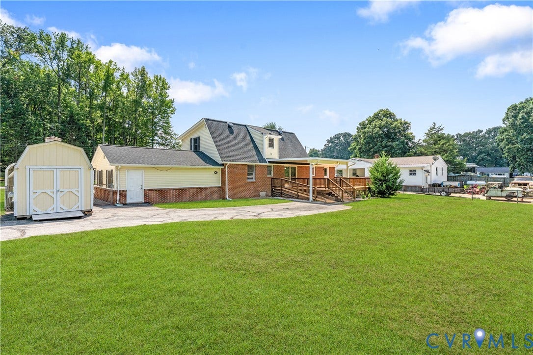 11612 Yorkdale Drive, Rivers Edge, North Prince George, VA 23860 Expansive green lawn with mature trees, a detached storage shed, covered porch, and a wood deck with ramp access