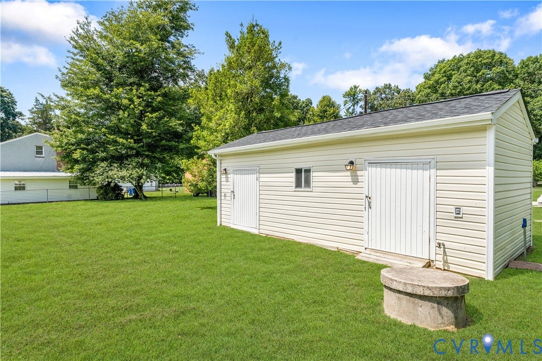 11612 Yorkdale Drive, Rivers Edge, North Prince George, VA 23860 Detached outbuilding with vinyl siding and a shingle roof, featuring two exterior doors and an outdoor light fixture