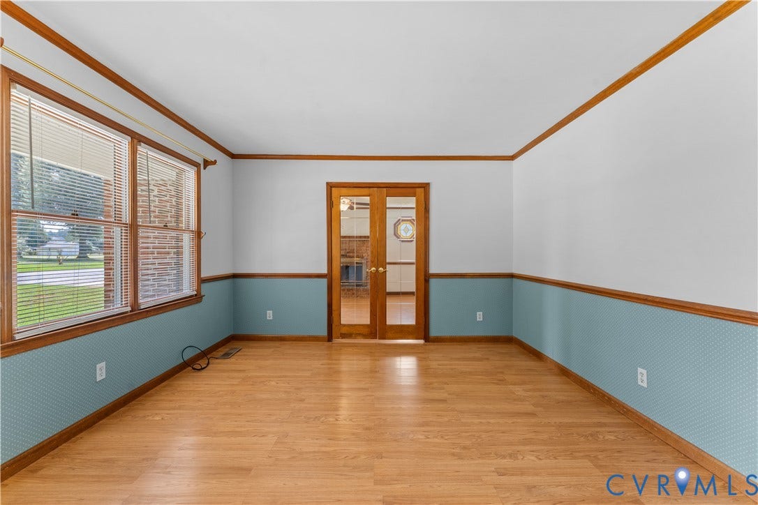 11612 Yorkdale Drive, Rivers Edge, North Prince George, VA 23860 Spacious room featuring rich wood-finish flooring, warm wood trim detailing, and two-tone wall treatment with blue-green lower paneling