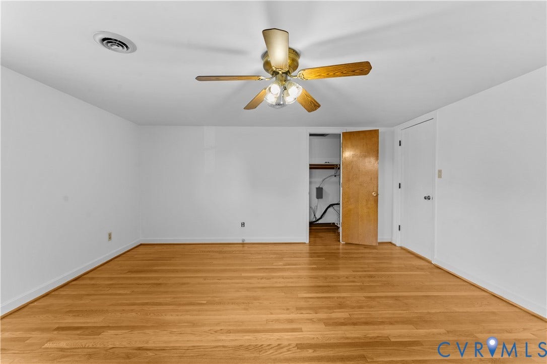 11612 Yorkdale Drive, Rivers Edge, North Prince George, VA 23860 Hardwood flooring, white walls, flush-mounted ceiling fan with light fixture, interior closet access, and a solid core door
