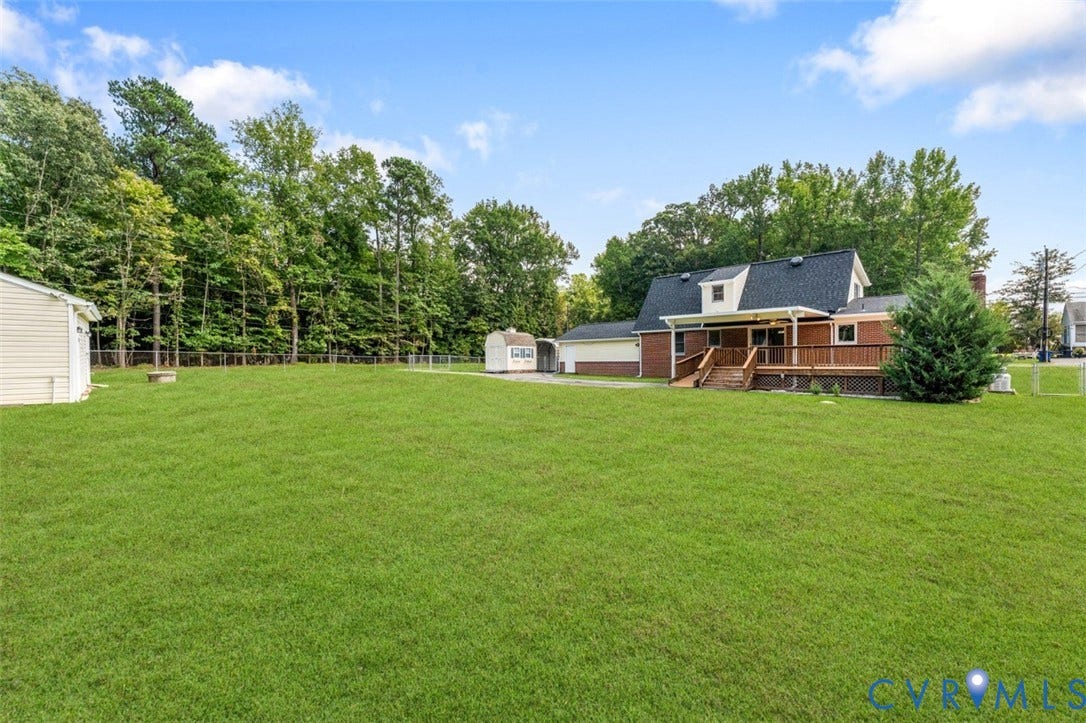 11612 Yorkdale Drive, Rivers Edge, North Prince George, VA 23860 Expansive manicured lawn with mature tree line bordering the property, brick residence with covered front porch, detached outbuildings, and open grounds ideal for outdoor space and potential expansion