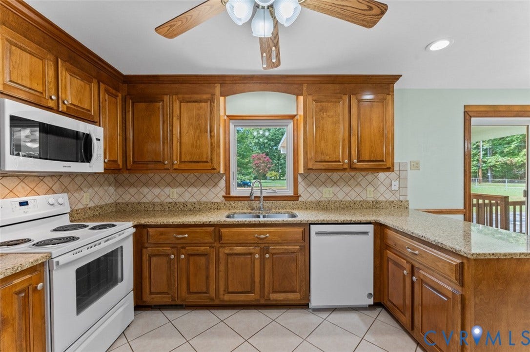 11612 Yorkdale Drive, Rivers Edge, North Prince George, VA 23860 Warm wood cabinetry and granite countertops define this well-appointed kitchen, featuring stainless steel appliances including a dishwasher, microwave, and range