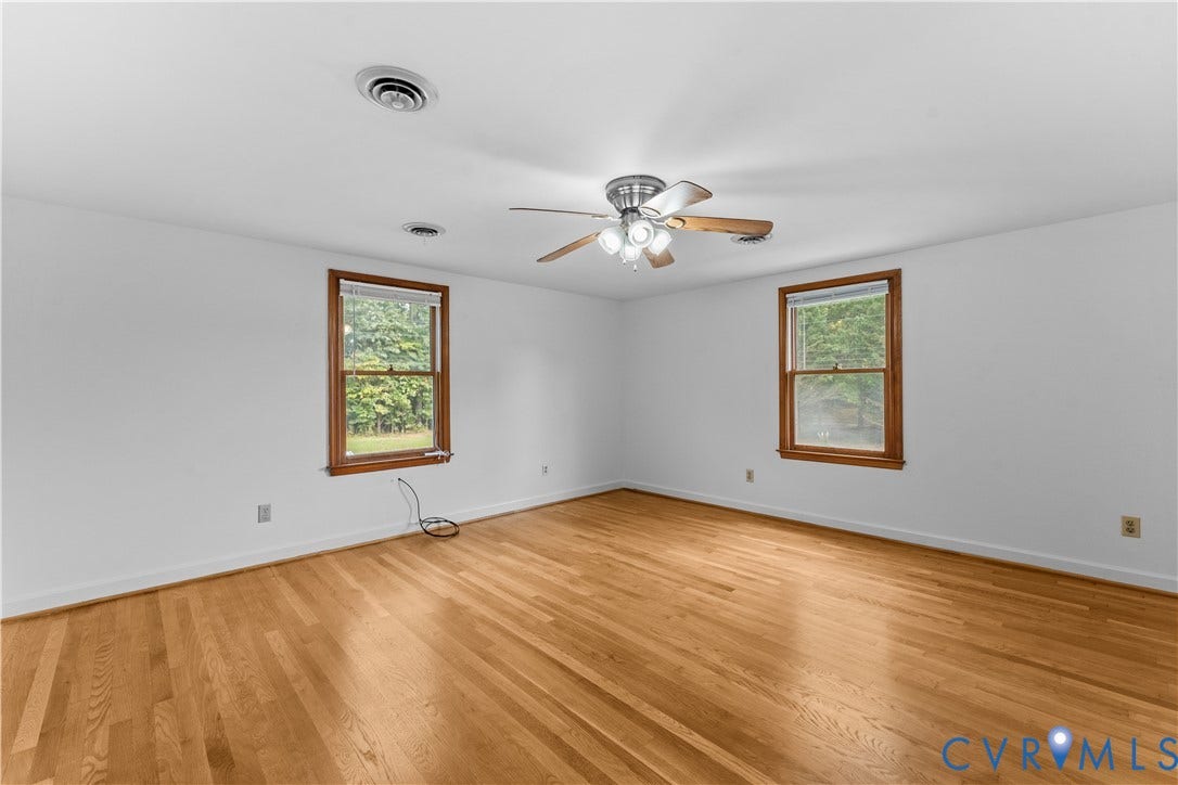 11612 Yorkdale Drive, Rivers Edge, North Prince George, VA 23860 Hardwood flooring, white walls, two windows with wood trim, and a ceiling fan with integrated lighting