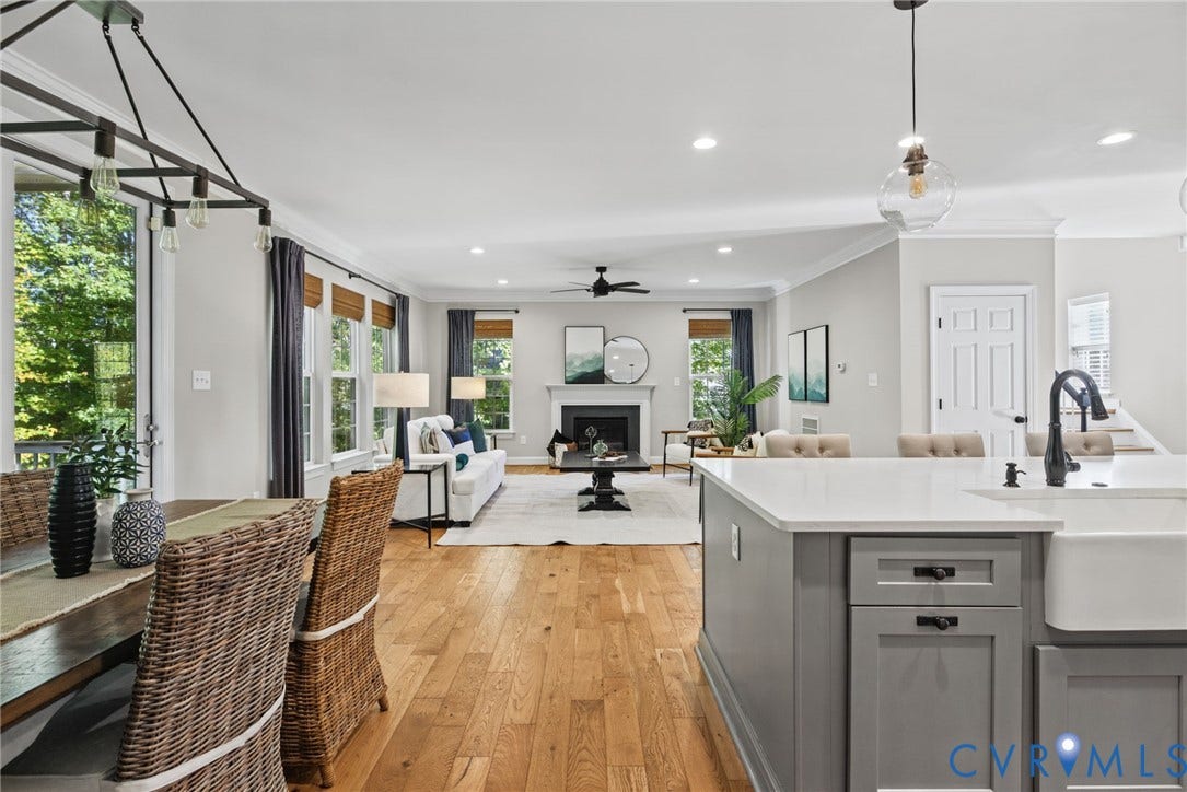 1425 Montcroft Way, Midlothian, VA 23112 Open-concept living space featuring hardwood flooring, a gas fireplace with a dark mantel, and abundant natural light from large multi-pane windows