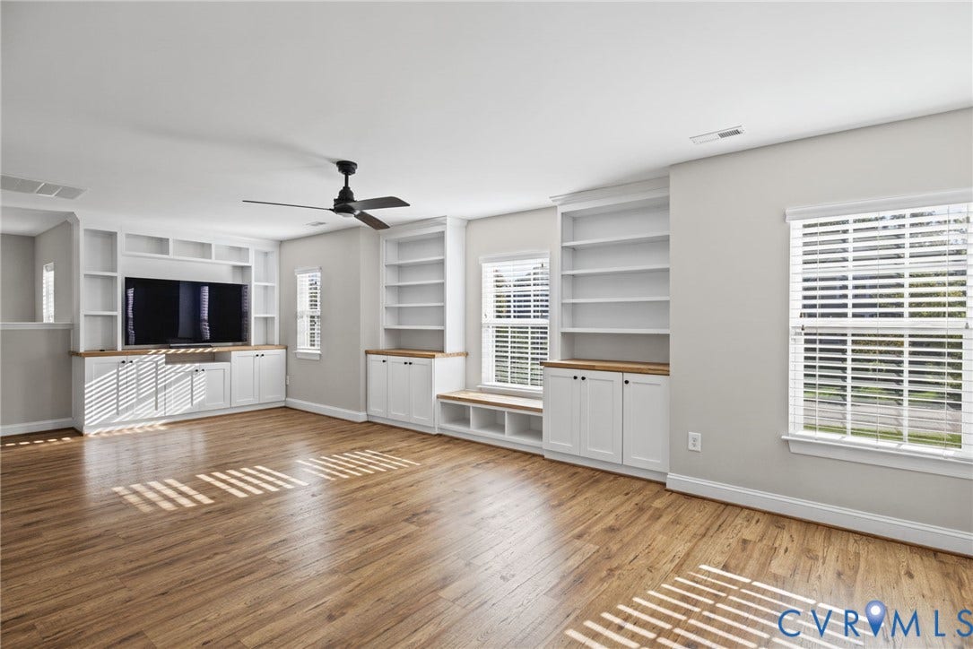 1425 Montcroft Way, Midlothian, VA 23112 Spacious room featuring wood-finish flooring, custom built-in cabinetry with natural wood-tone surfaces, integrated shelving, a window seat, and a ceiling fan